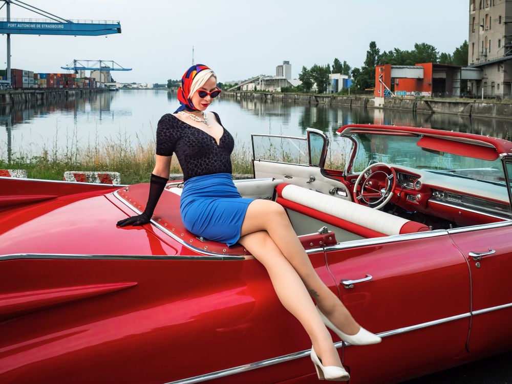 Old-timer red car and a young woman with scarf