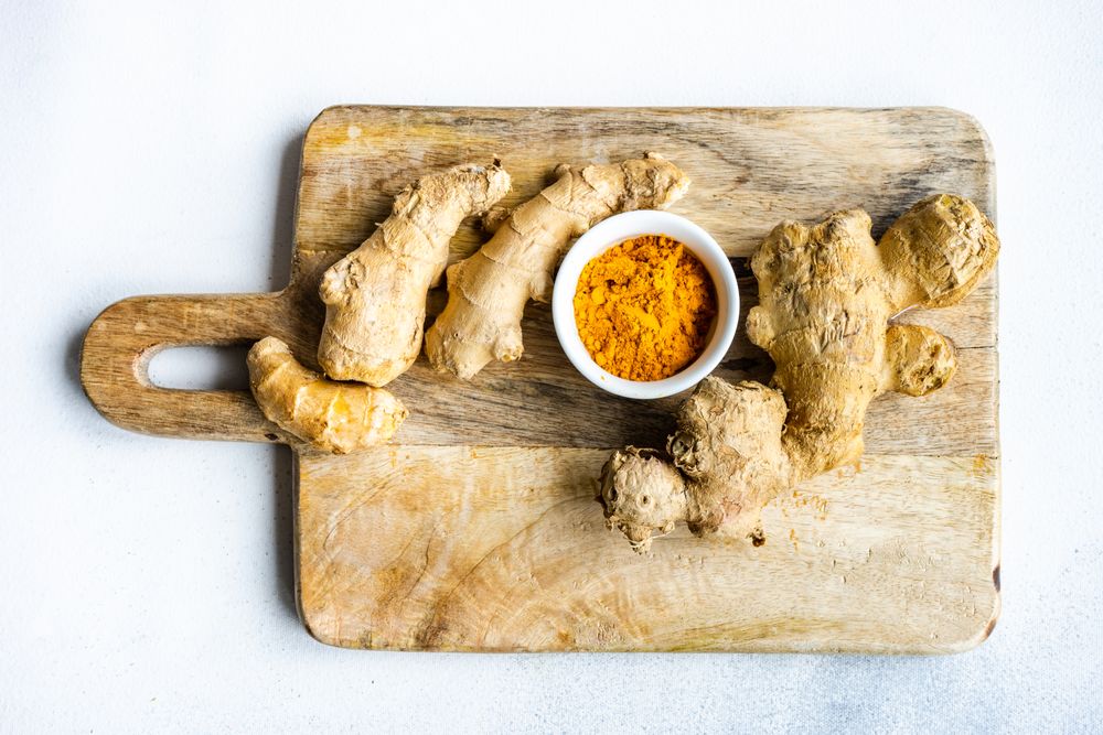 Top view of raw ginger & turmeric on board