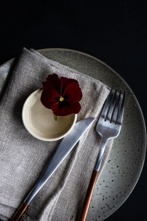 Close up of grey napkin with red flower
