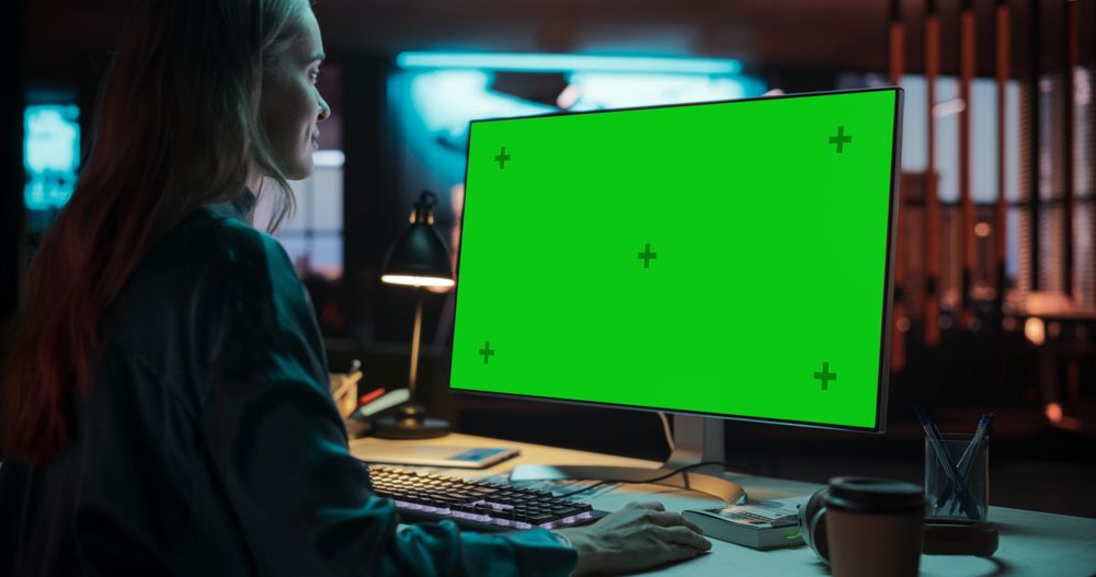 Over the Shoulder: Female Specialist Working on Computer with Chroma Key Display at Creative Agency.