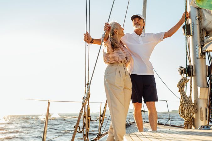 Mature couple standing together on sailboat