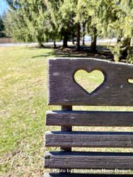 Brown wooden bench with heart carving in garden 5lKP70
