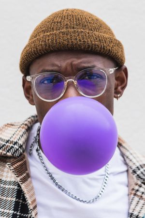 Trendy Black man blowing balloon