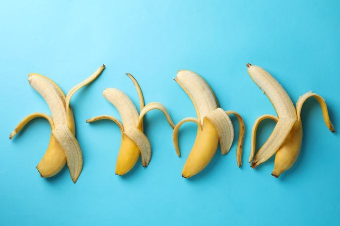 Opened bananas on blue background. Fresh fruit