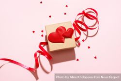 Small gift box with red heart and ribbon on pink background 0ypX7b