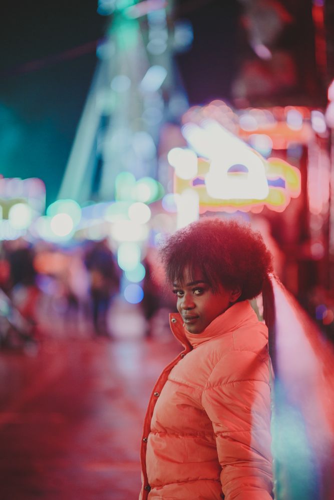 Black female standing near attraction in amusement park