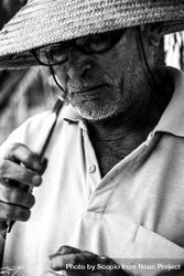 Close-up photo of an older man wearing eye glasses and hat in grayscale 5zK9k4