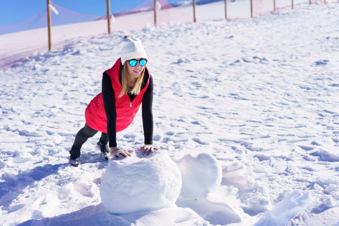 Happy woman warming up on snow terrain in winter