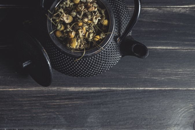 Spoonful of dried chamomile on brass teapot
