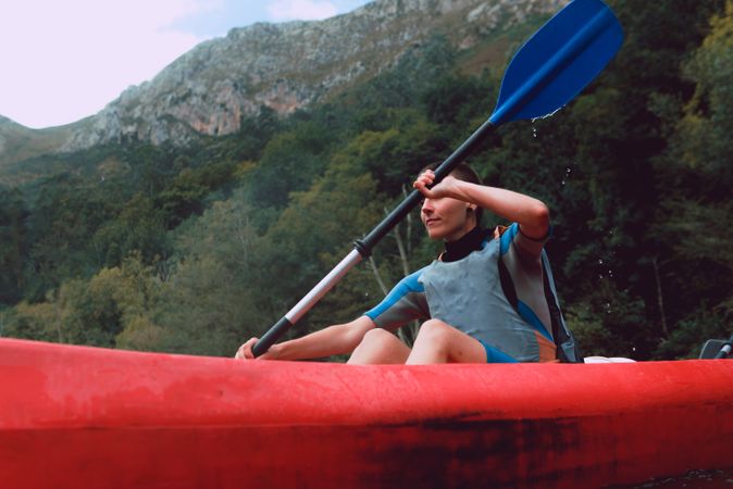 Young female kayaking on nature background
