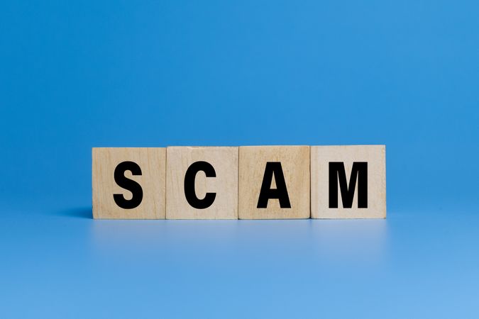 scam word text on wooden blocks isolated on blue background