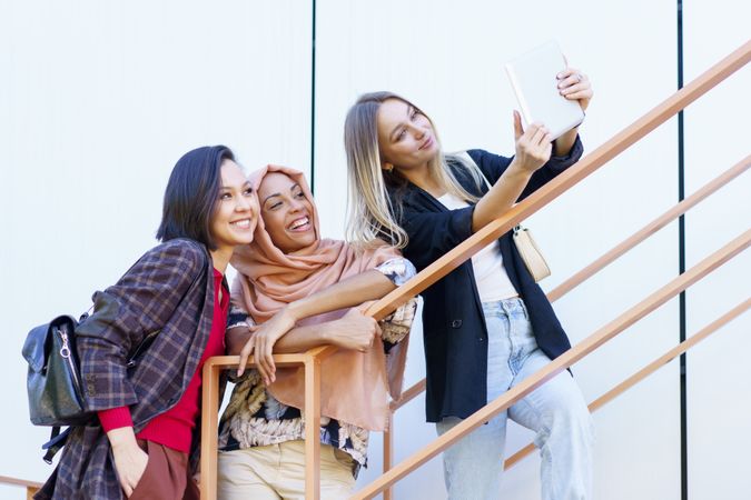 Three smiling women taking selfie on digital tablet