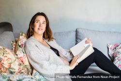 Relaxed pregnant woman reading a book on sofa 4my6e4