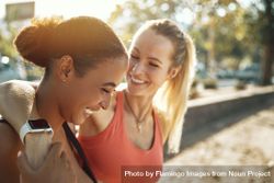 Blonde woman smiling with her arm around her friend 43e6r0