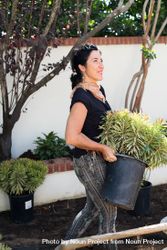 Woman carrying potted plant bGKwlb