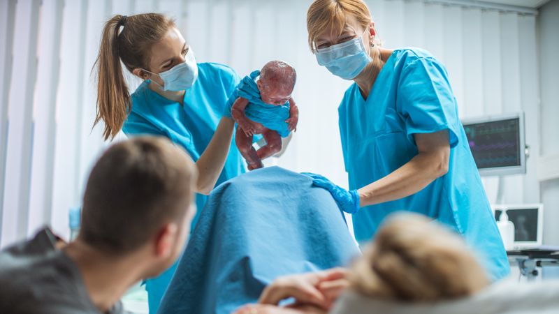 In the Hospital Midwive Holding Infant Baby