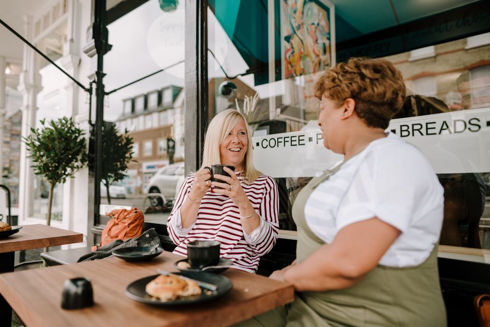Two older woman chatting over coffee and tea at cafe