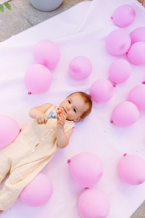Cute baby on lying with colorful balloons