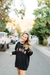 Woman wearing dark sweatshirt standing on street