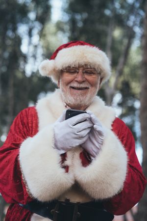 Happy Santa Claus with smartphone