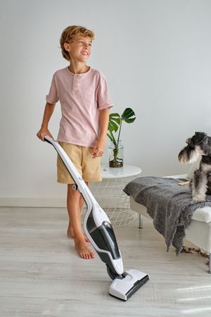 Glad boy cleaning living room floor