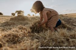 Cute girl lifting a hay from the ground 5QAmm5