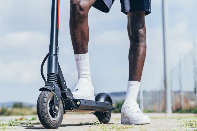 Black man riding on electric scooter in park
