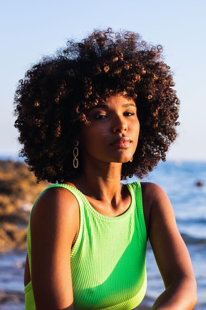dreamy Black woman standing in sea during summer vacation