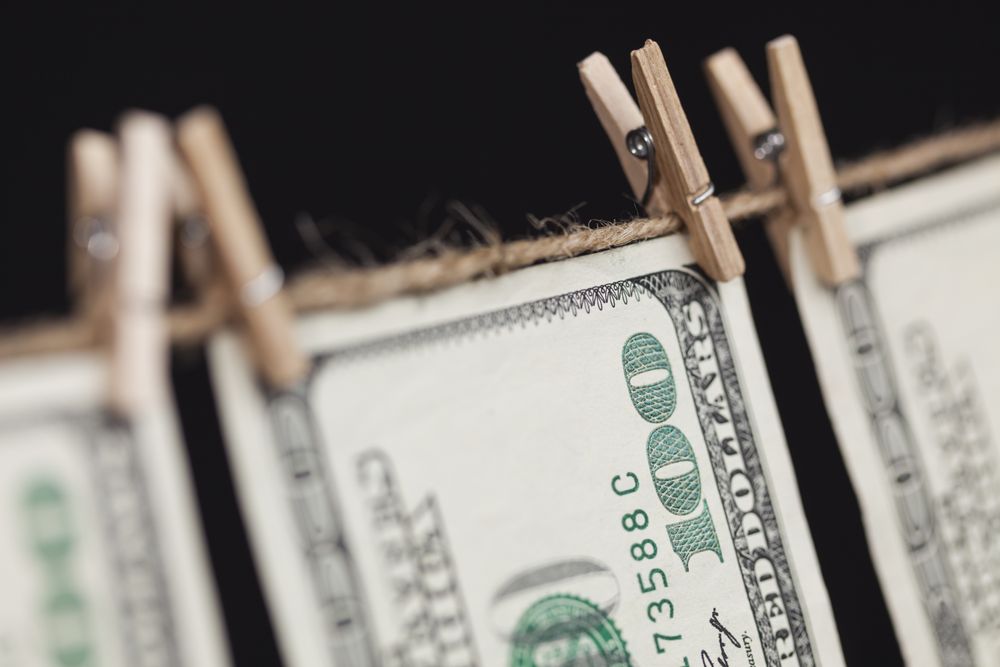 Hundred Dollar Bills Hanging From Clothesline on Dark Background