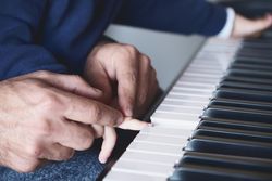 Anonymous father teaching son to play piano