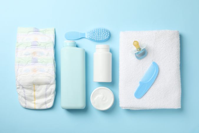 Flat lay with baby hygiene accessories on blue background