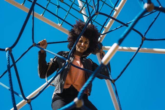 Woman with afro hair climbing by children's attractions.