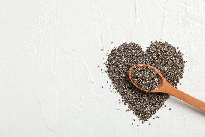 Heart layout of chia and wood spoon on neutral background, space for text