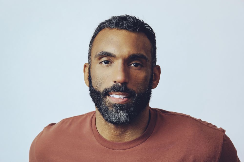 Head shot of bemused Black male in grey studio
