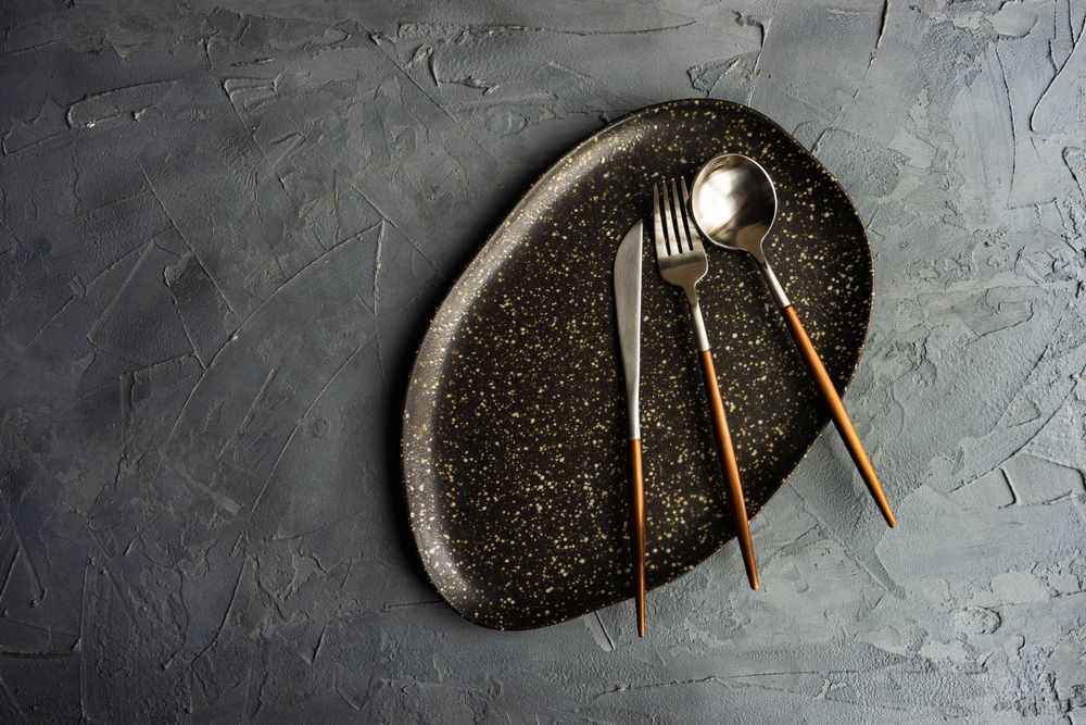 Dark plate with wooden handled cutlery