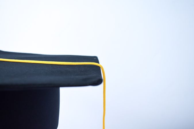 Side view of graduation cap in plain studio with copy space