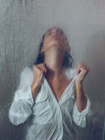 Sensitive woman in wet shower cabin