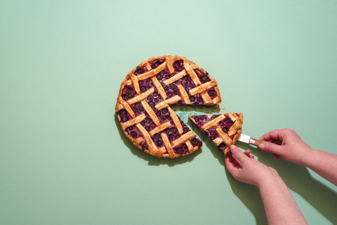 Woman taking slice of blueberry pie