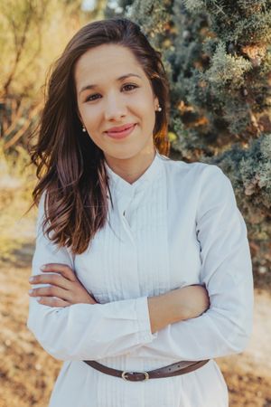 Confident young lady standing in park