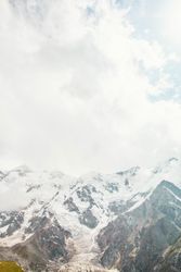 Vertical composition of mountains behind clouds in Fairy Meadows, Pakistan