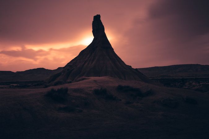 Stone peak in desert against evening sky