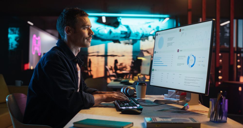 Portrait of Professional Male Developer Using Desktop Computer and Typing in Creative Office.