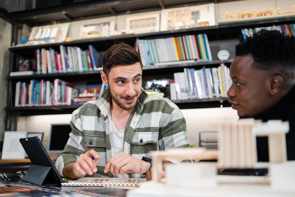 Two happy male colleagues working on design project
