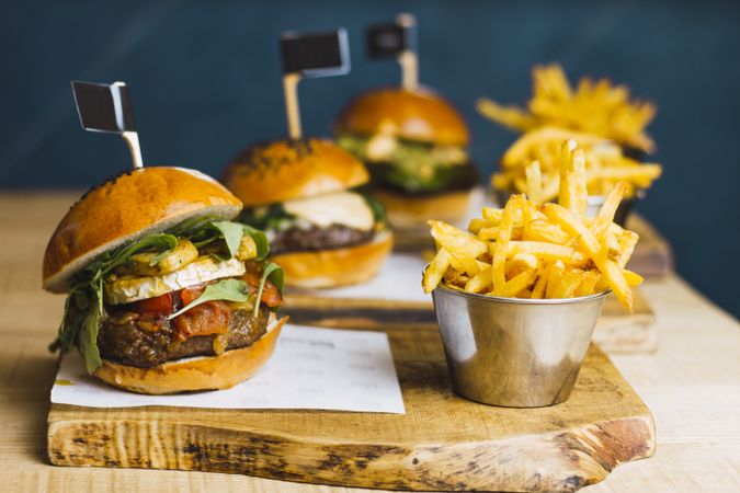 Juicy delicious burger and fried potato on table