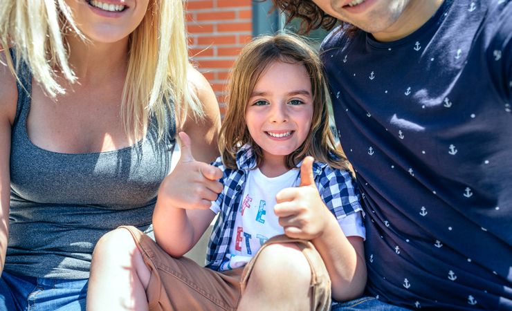 Child with parents in front of new home