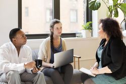 Three people sharing ideas in a meeting