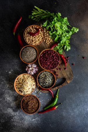 Bowls of different dried beans & grains on cutting board