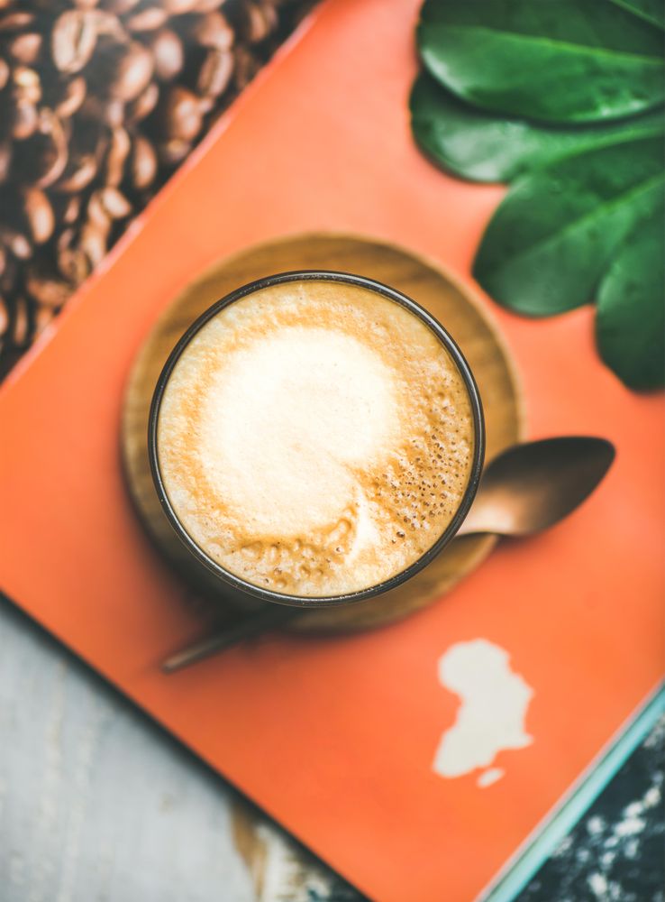 Top view of latte on orange table setting with outline of Africa