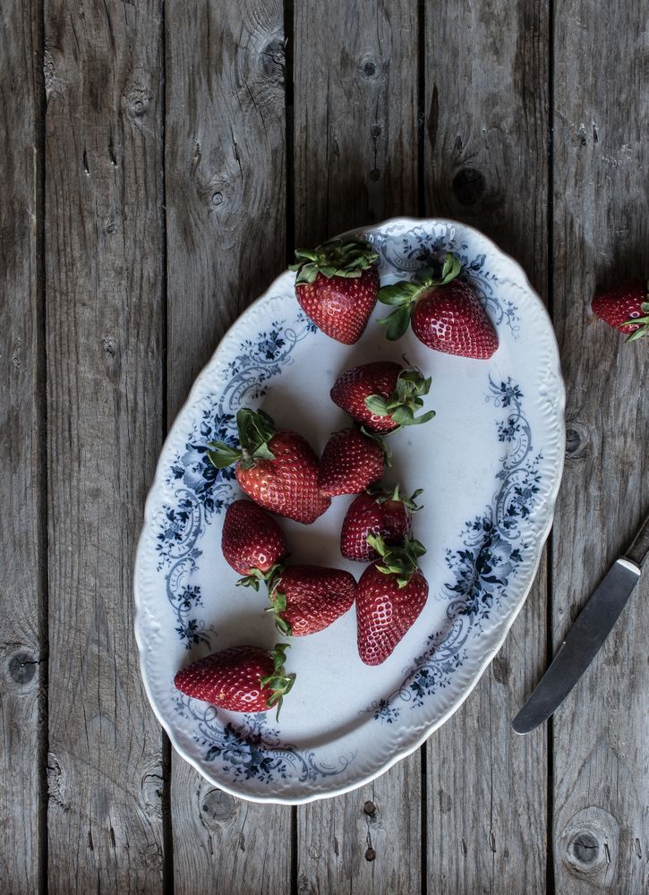 Plate with strawberries near napkin and knife