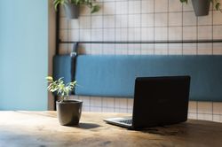 Laptop in the shadows in blue tiled room